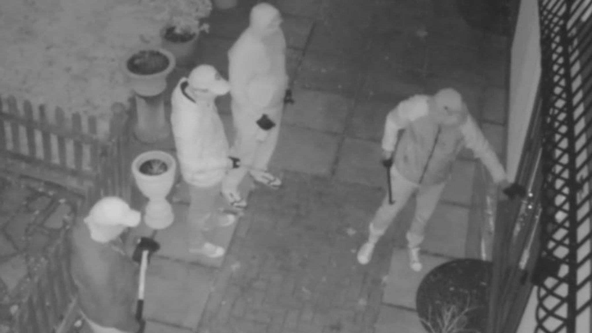 Night CCTV footage of people approaching a home entrance